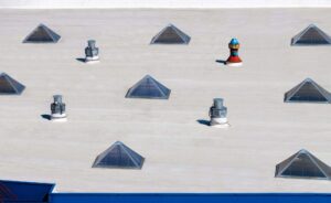 Top view flat roof with air conditioners and pyramidal windows on top 