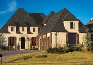 A house with stucco siding and a black shingle roof.
