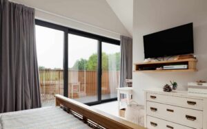 Bedroom with large sliding patio style windows leading to outside balcony