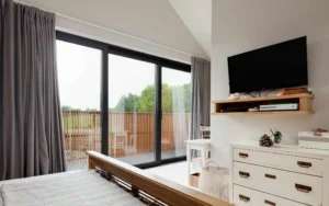 Bedroom with large sliding patio style windows leading to outside balcony